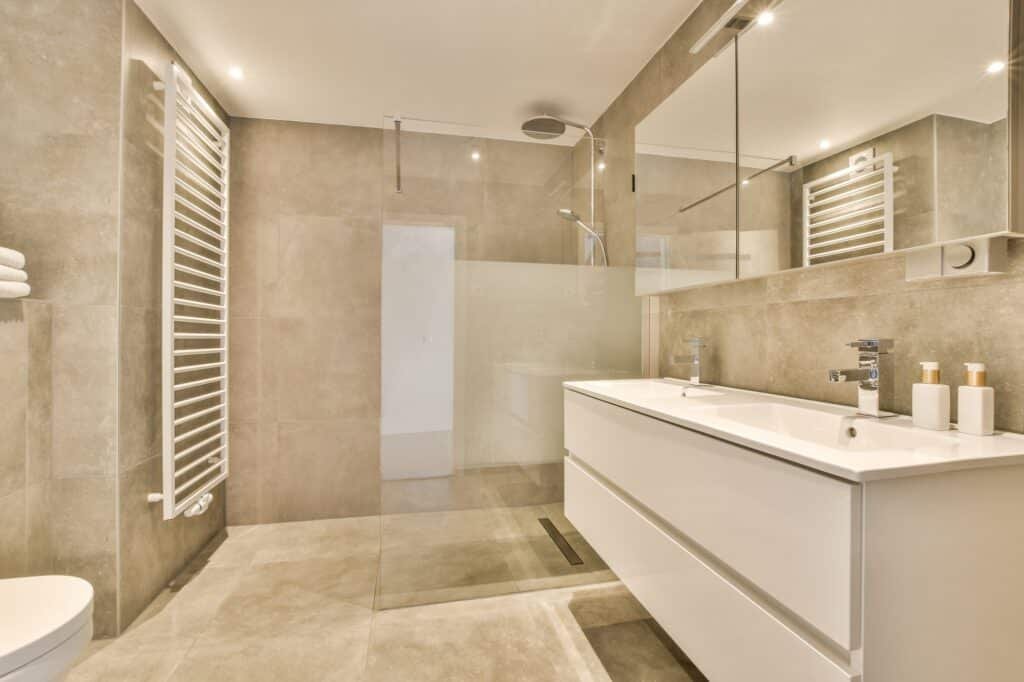 Vue d’une salle de bain à Amiens avec douche à l’italienne, double vasque et carrelage gris clair.