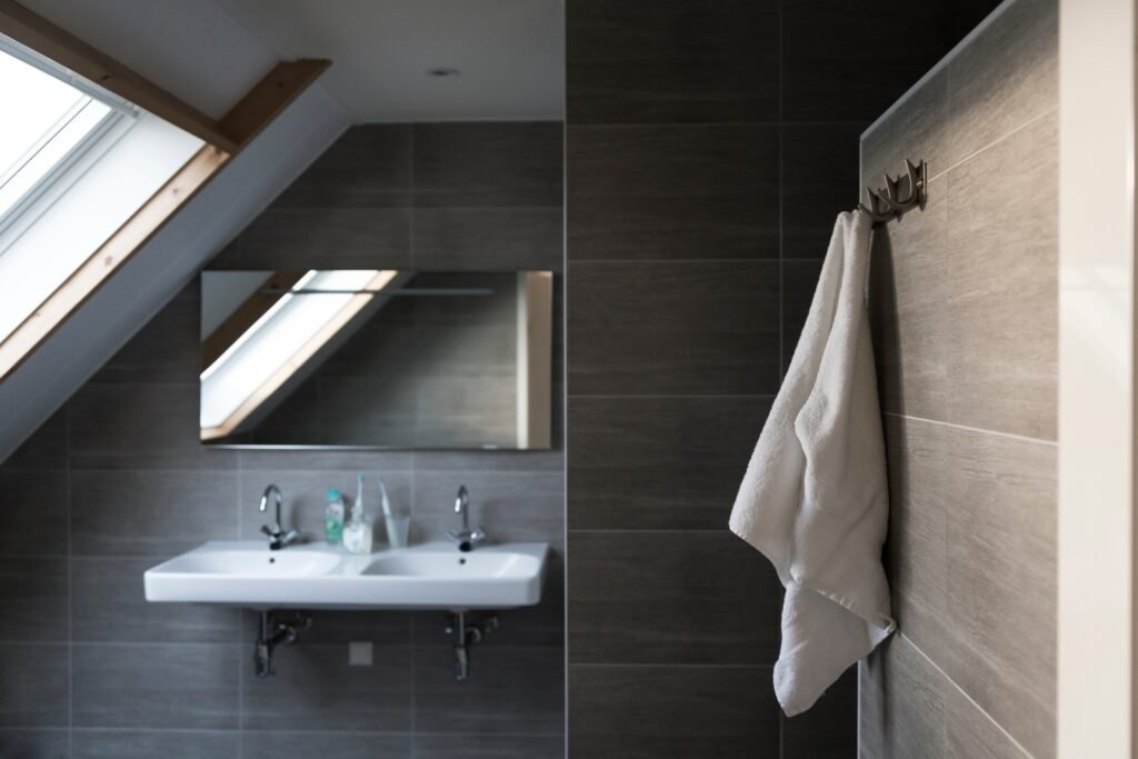 Salle de bain à Amiens sous comble avec double vasque, douche à l’italienne et serviette accrochée.