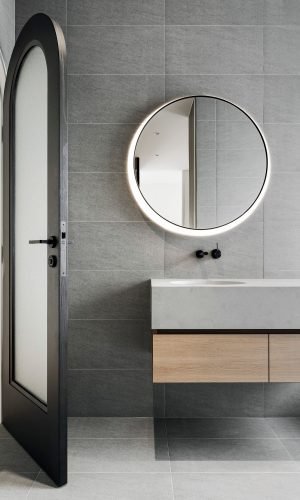 Lavabo moderne à Amiens avec plomberie de salle de bain apparente et miroir rond lumineux.